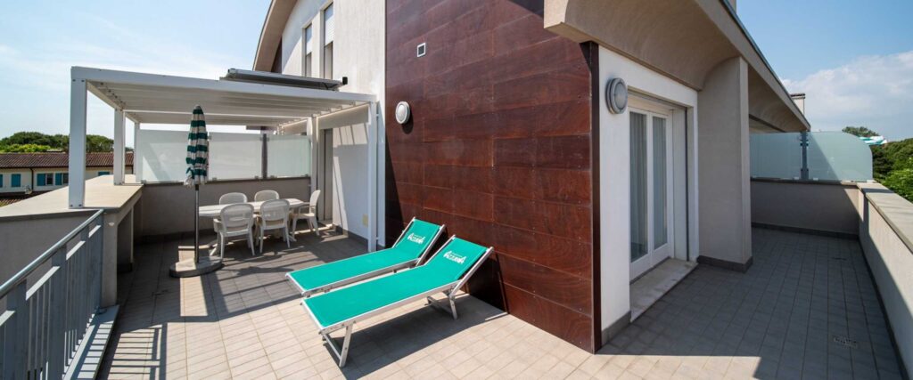 Terrazza con lettini e tavolo a Bibione